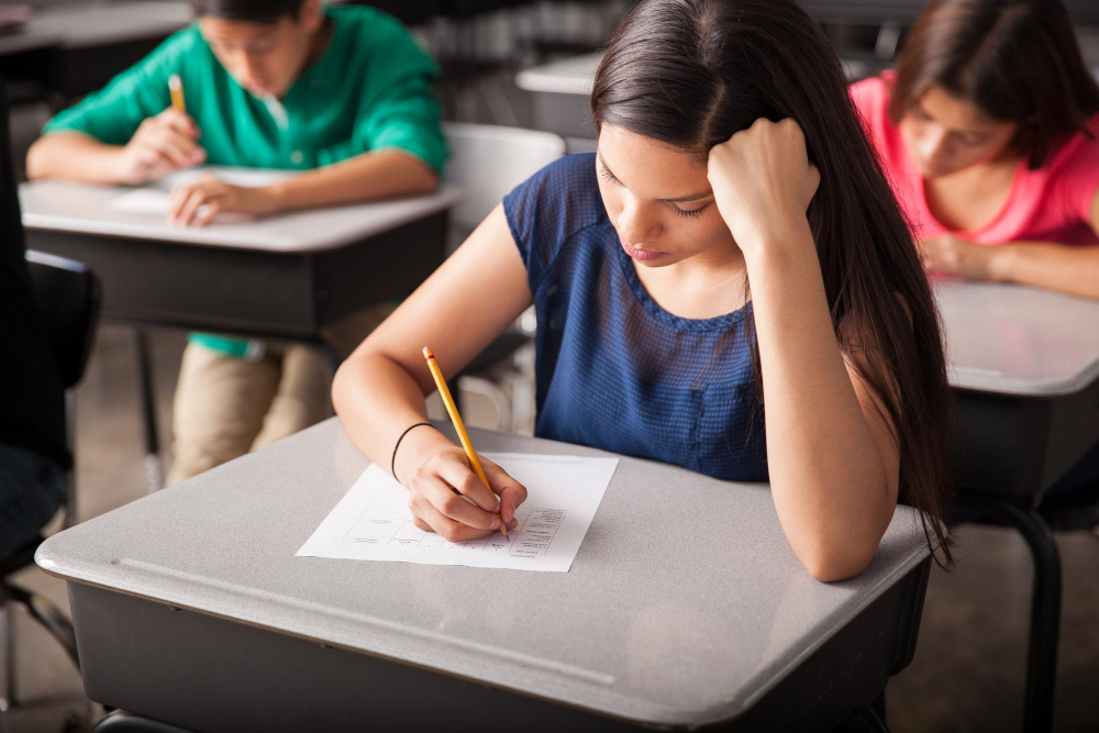 A female primary school student taking an exam at her desk