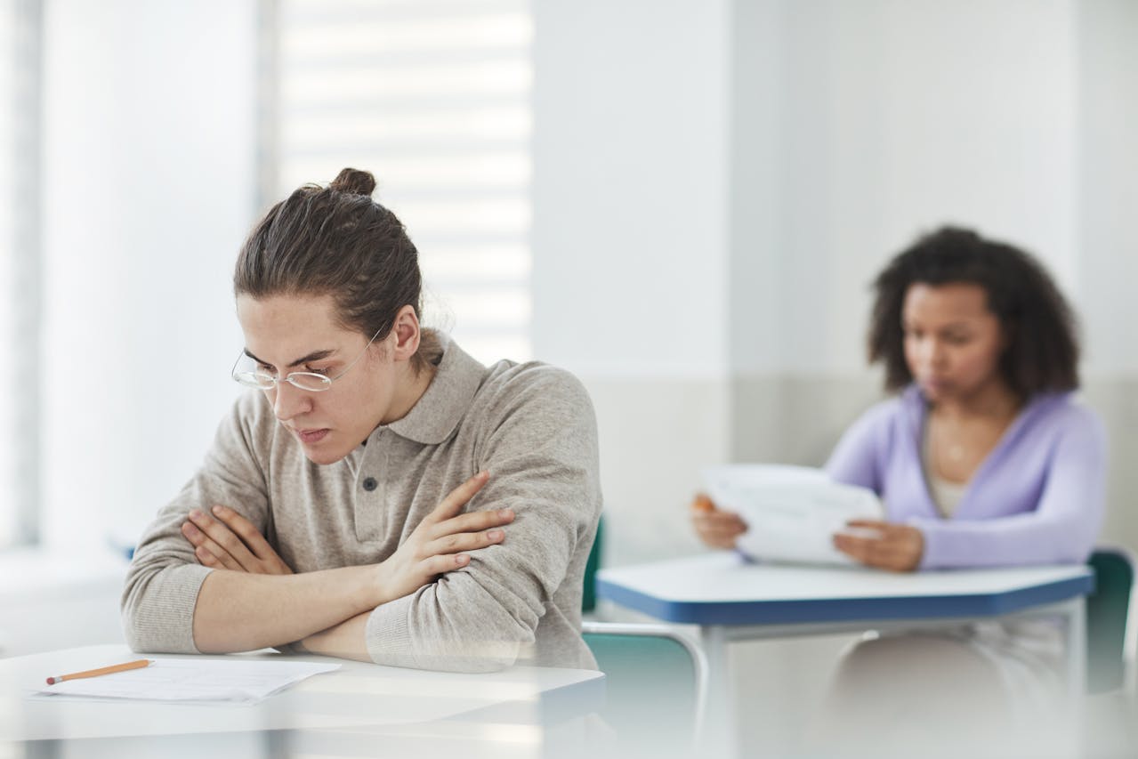 A male and female student taking a test at their desks